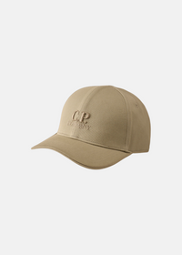 Casquette de baseball C.P. Company en gabardine beige vue de trois quarts face sur fond uni blanc