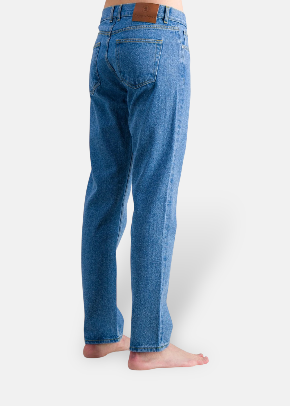 Ateliers de Nîmes jeans dn20 porté de derrière en profil avec un détail sur l'étiquette.