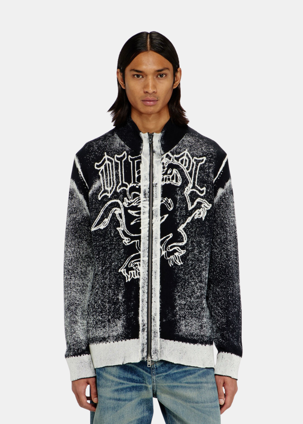 Mannequin homme portant de face le cardigan zippé noir et blanc Diesel avec motif griffon graphique et un jean bleu.