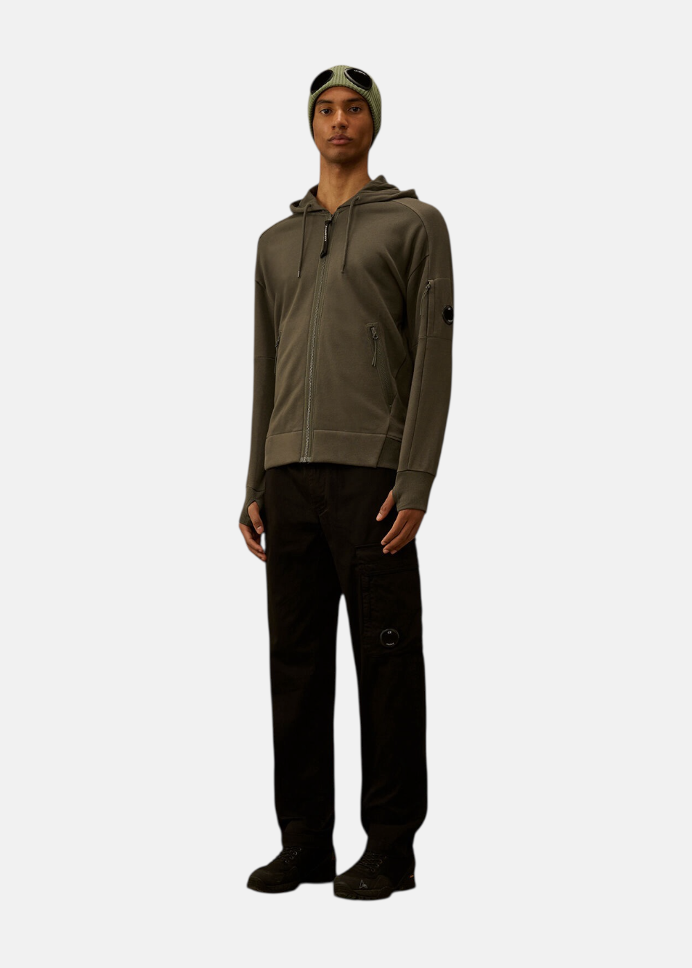Silhouette complète avec sweat zippé kaki, pantalon cargo noir.