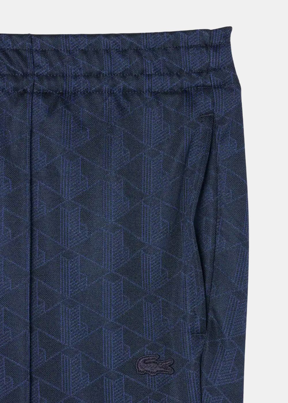 Gros plan sur la maille jacquard à monogramme bleu marine et le crocodile brodé ton sur ton Lacoste.