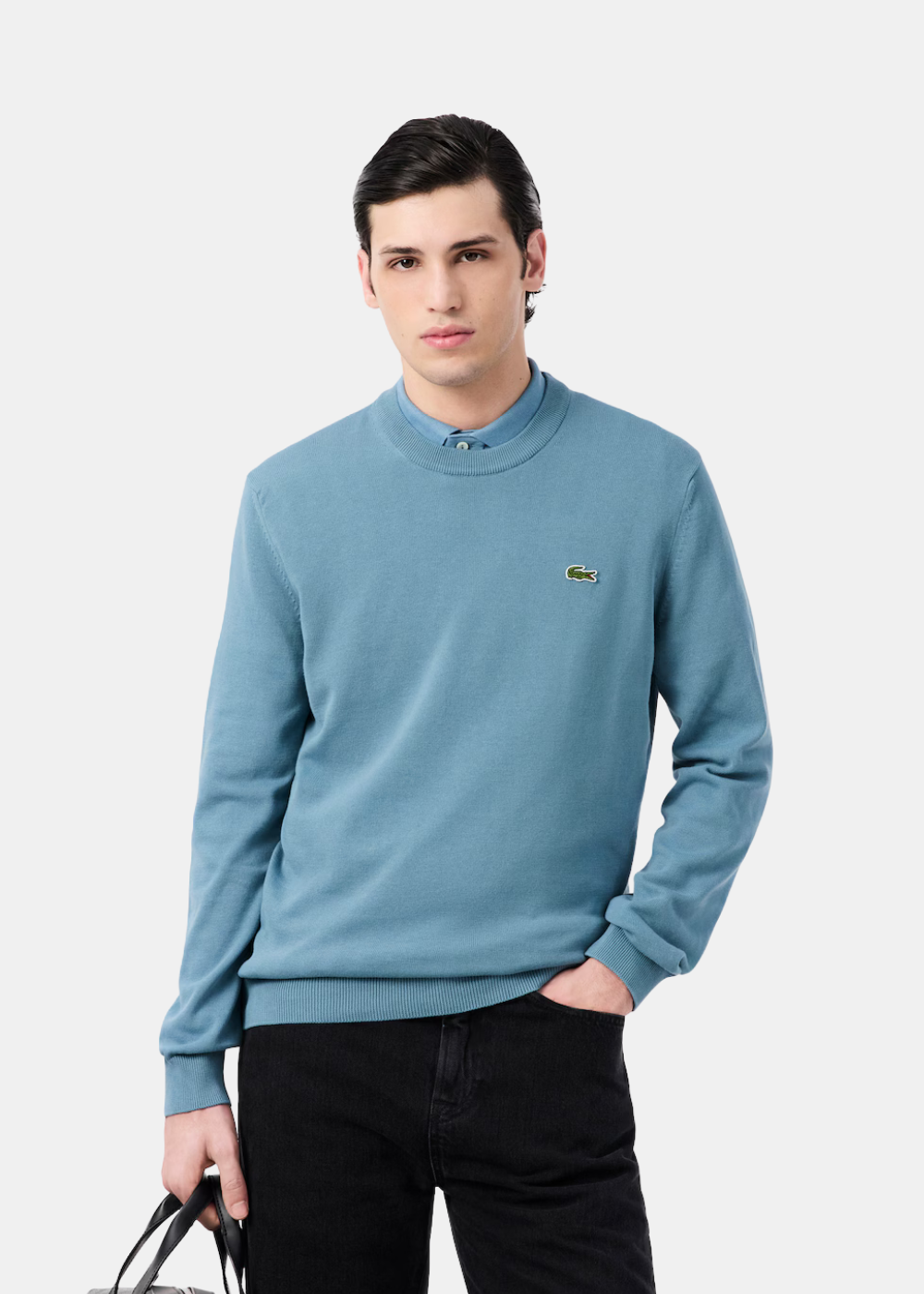 Mannequin portant le pull col rond Lacoste bleu gris en jersey de coton sur une chemise.