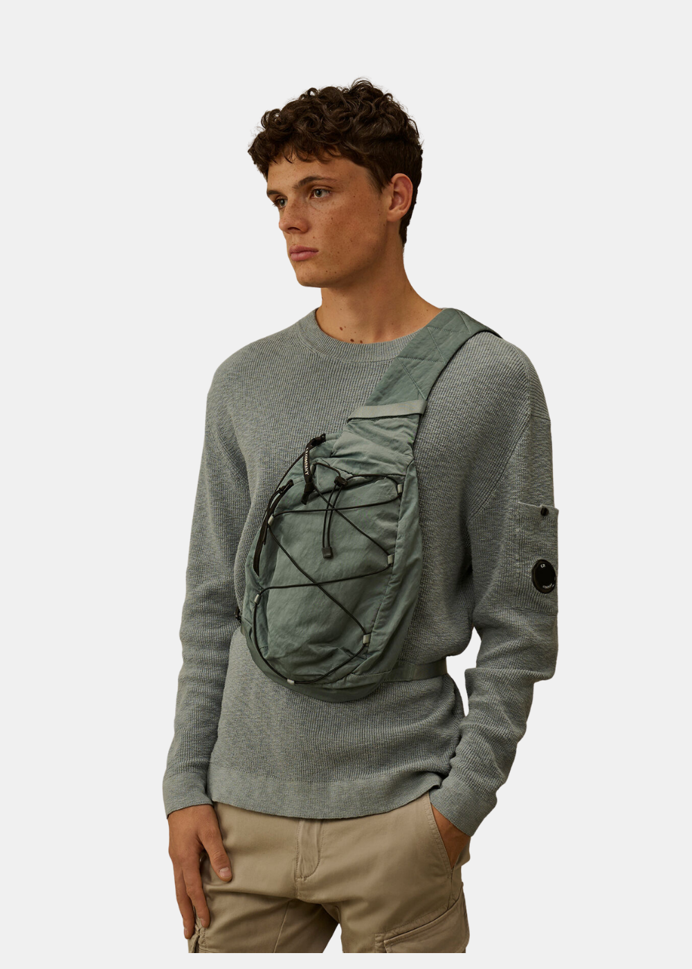 Mannequin portant le sac bandoulière bleu C.P. Company en travers du buste sur un pull bleu