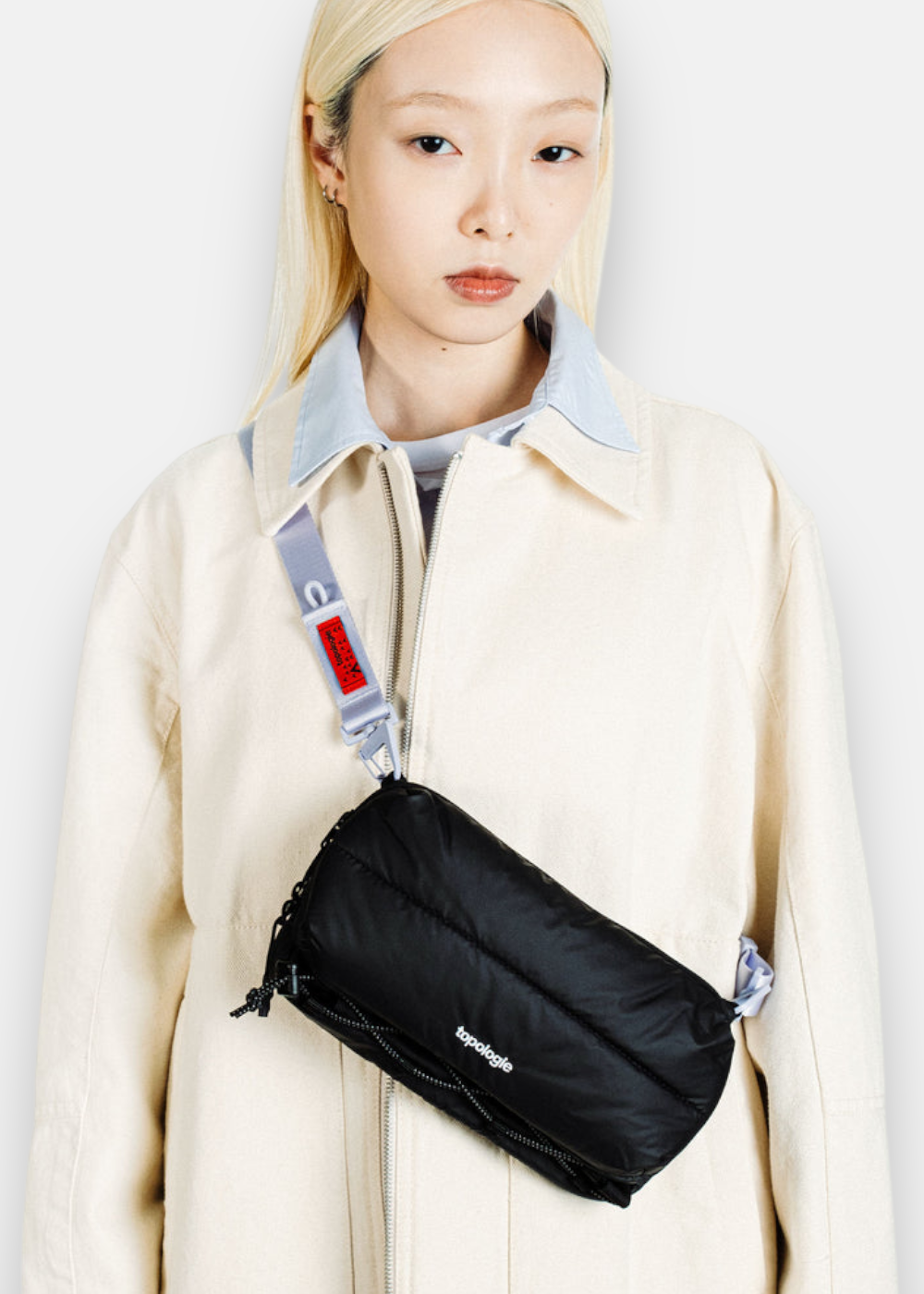 Outfit avec la Sacoche Topologie bottle water puffer noir porté par un mannequin femme.