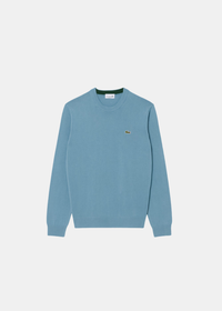 Packshot de face du pull col rond Lacoste en jersey de coton biologique bleu gris avec crocodile brodé