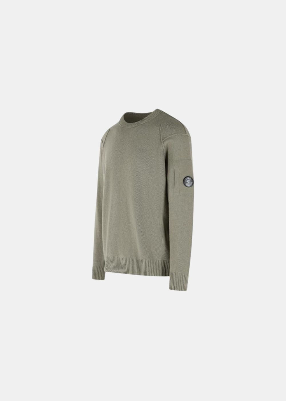 Packshot de profil sur fond gris d'un pull col rond C.P. Company en laine lambswool GRS couleur kaki, avec détails de coutures apparentes aux épaules et poche à lentille sur la manche gauche