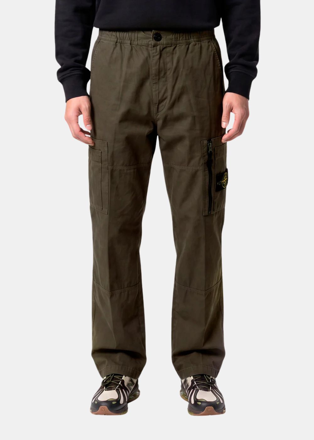 Modèle masculin portant le pantalon cargo Stone Island de face, associé à un sweat noir et des sneakers. Met en valeur la coupe droite moderne (Regular/Loose Fit) et le rendu de la teinture en pièce (Garment Dyed).