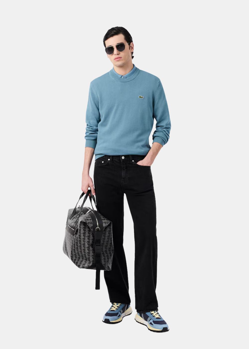 Tenue complète avec le pull col rond Lacoste bleu gris associé à un pantalon noir pour un style minimaliste.