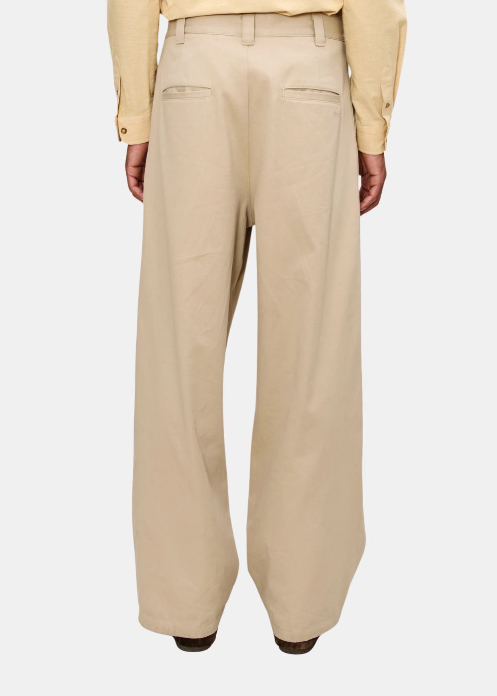 Vue arrière du pantalon beige A.P.C. montrant les poches passepoilées et la coupe large.