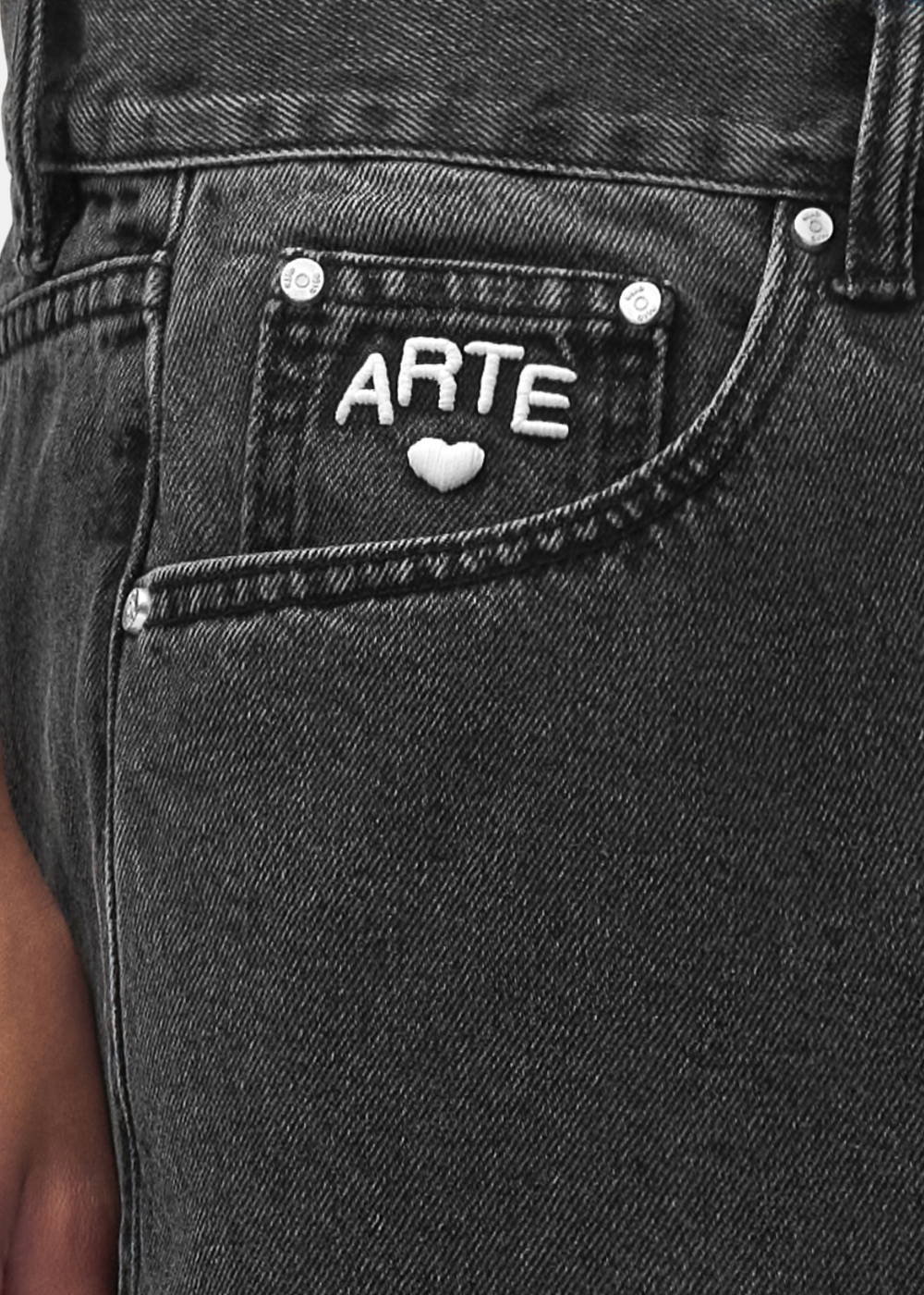 Gros plan sur la poche gousset du jean noir Arte-Antwerp montrant la broderie blanche ARTE cœur.