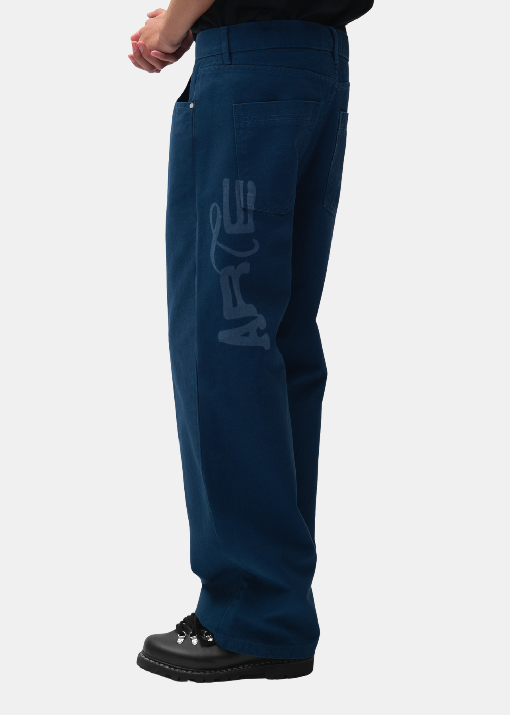 Vue de profil du pantalon bleu marine Arte-Antwerp montrant la coupe ample et l'imprimé ARTE sur le côté.