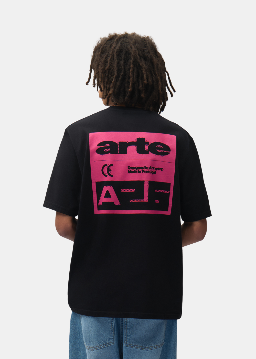 Plan buste de dos d'un mannequin portant le t-shirt noir Arte-Antwerp avec imprimé rose.
