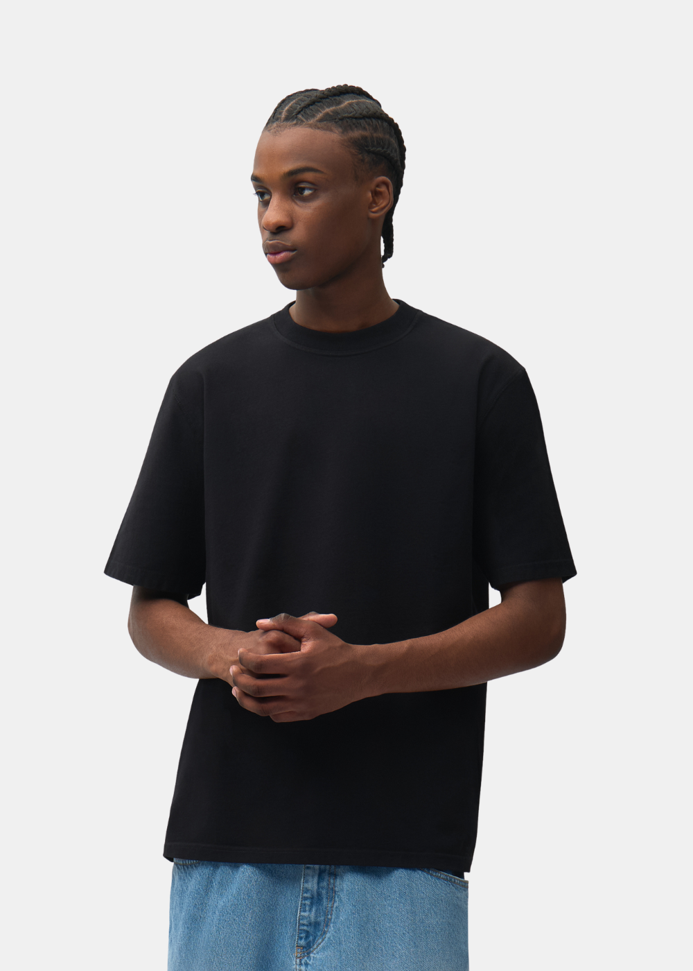Plan buste de face d'un mannequin avec tresses portant le t-shirt noir uni Arte-Antwerp.