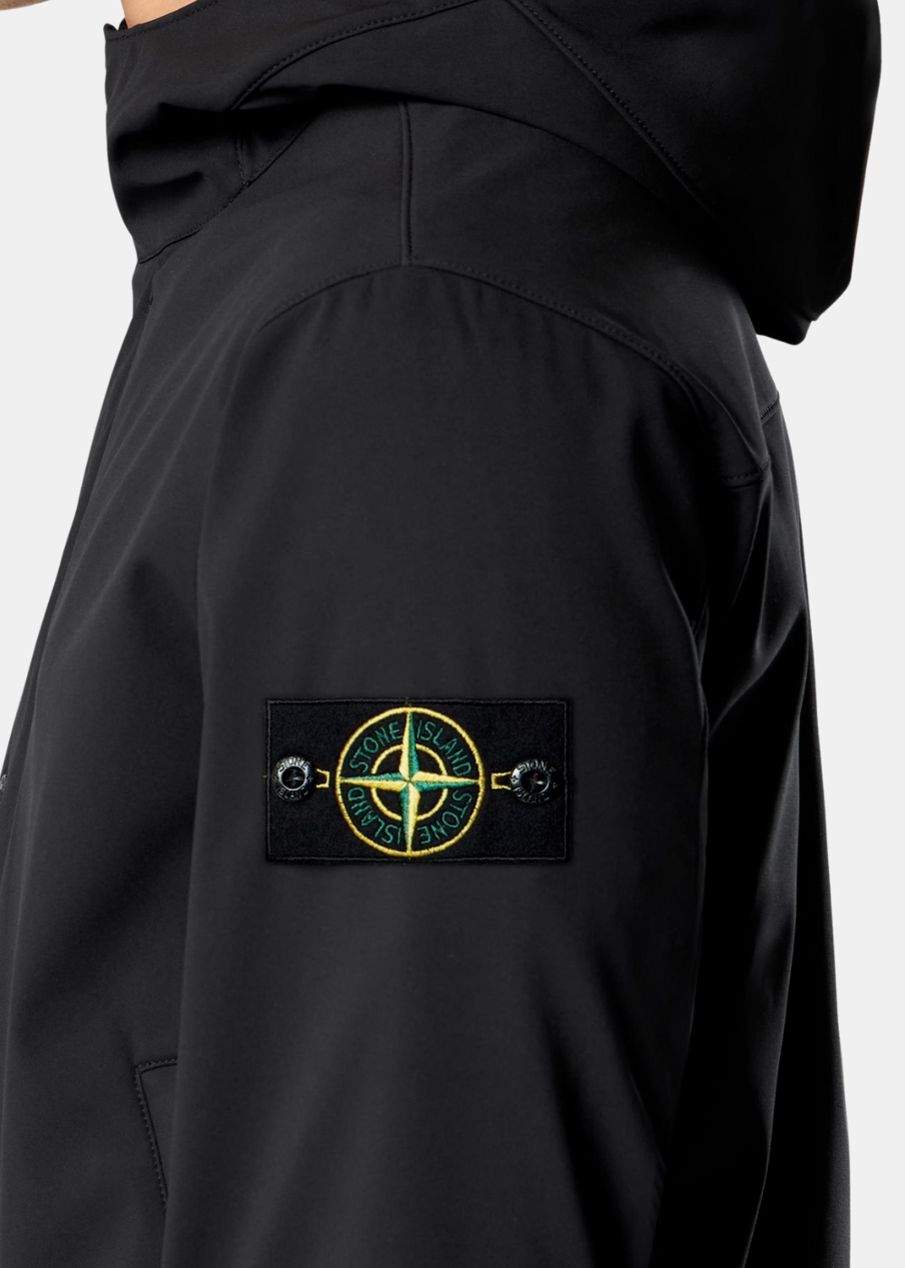 Détail du badge boussole Stone Island amovible sur la manche gauche de la veste noire.