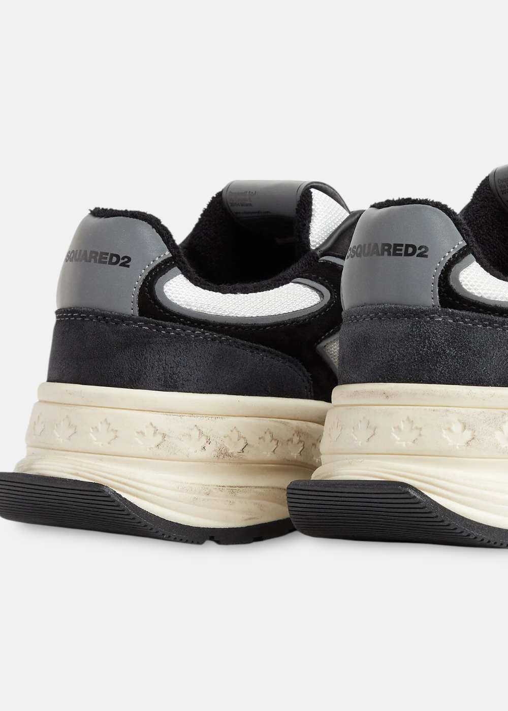 Gros plan sur l'arrière des baskets mettant en avant les détails de la semelle beige effet vintage et les logos.
