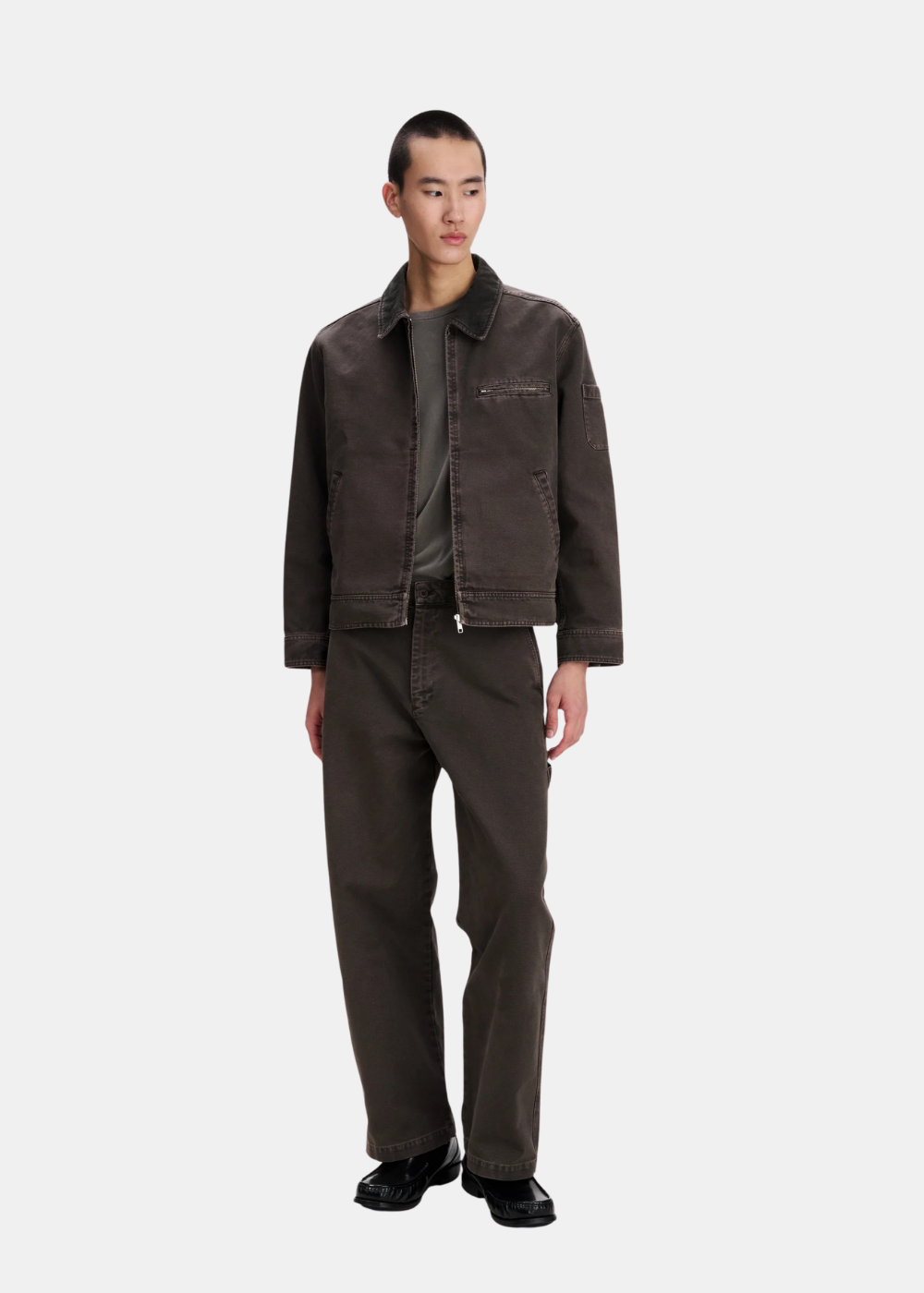 Silhouette portée du blouson workwear marron A.P.C. en toile de coton avec pantalon assorti et t-shirt vert
