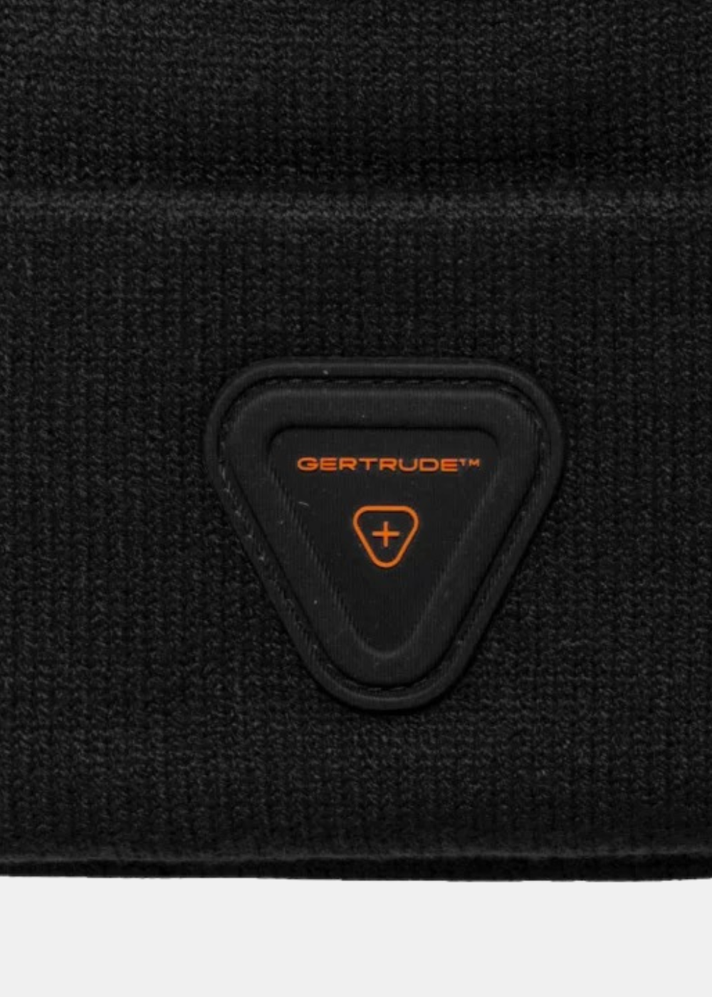 Gros plan sur le patch en silicone triangulaire noir avec logo orange Gertrude fixé sur le revers du bonnet en maille.