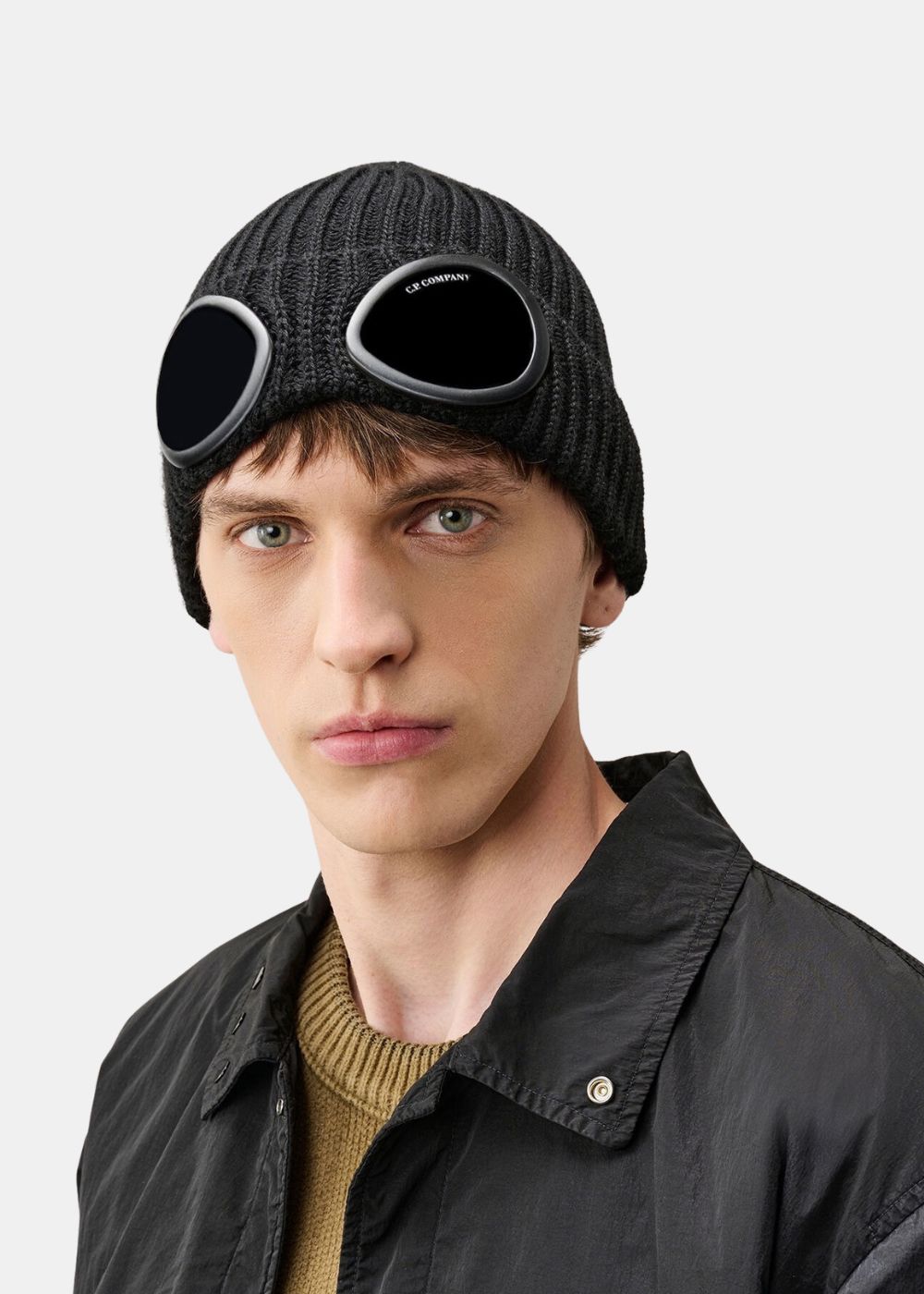Vue de face portée du bonnet noir C.P. Company en laine côtelée avec lunettes Goggle rabaissées