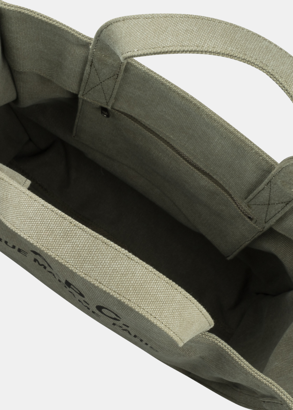 Vue de l'intérieur du cabas A.P.C. en toile kaki avec sa poche zippée intégrée