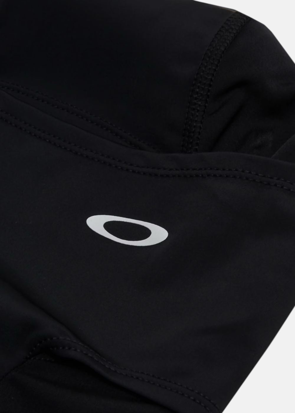 Gros plan sur le logo Oakley Ellipse blanc imprimé et les coutures de la cagoule Backwoods Balaclava