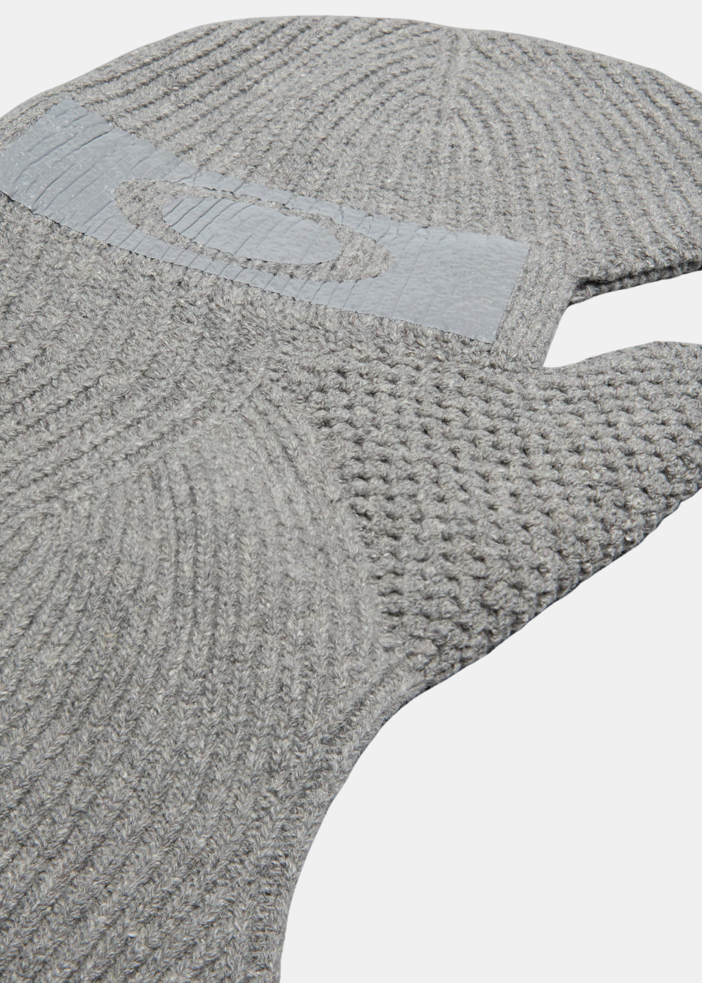 Gros plan sur la maille de la cagoule Oakley grise en tricot laine et soie avec le logo Ellipse