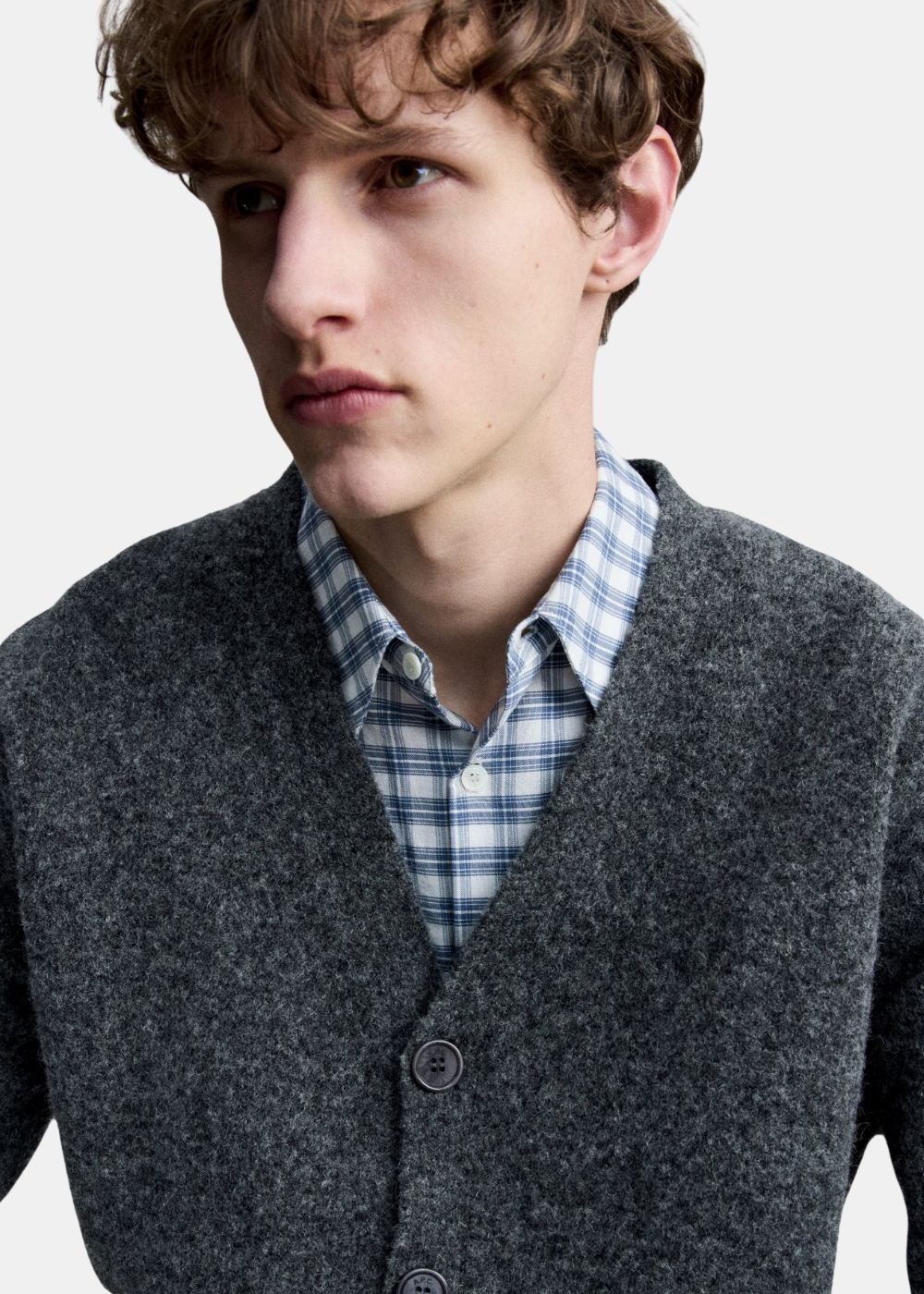 Gros plan sur le col V, la maille en laine d'alpaga et la fermeture boutonnée du cardigan gris anthracite A.P.C.