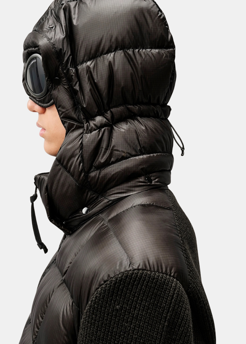 Gros plan de profil sur la capuche fermée C.P. Company affichant les lunettes Goggle iconiques