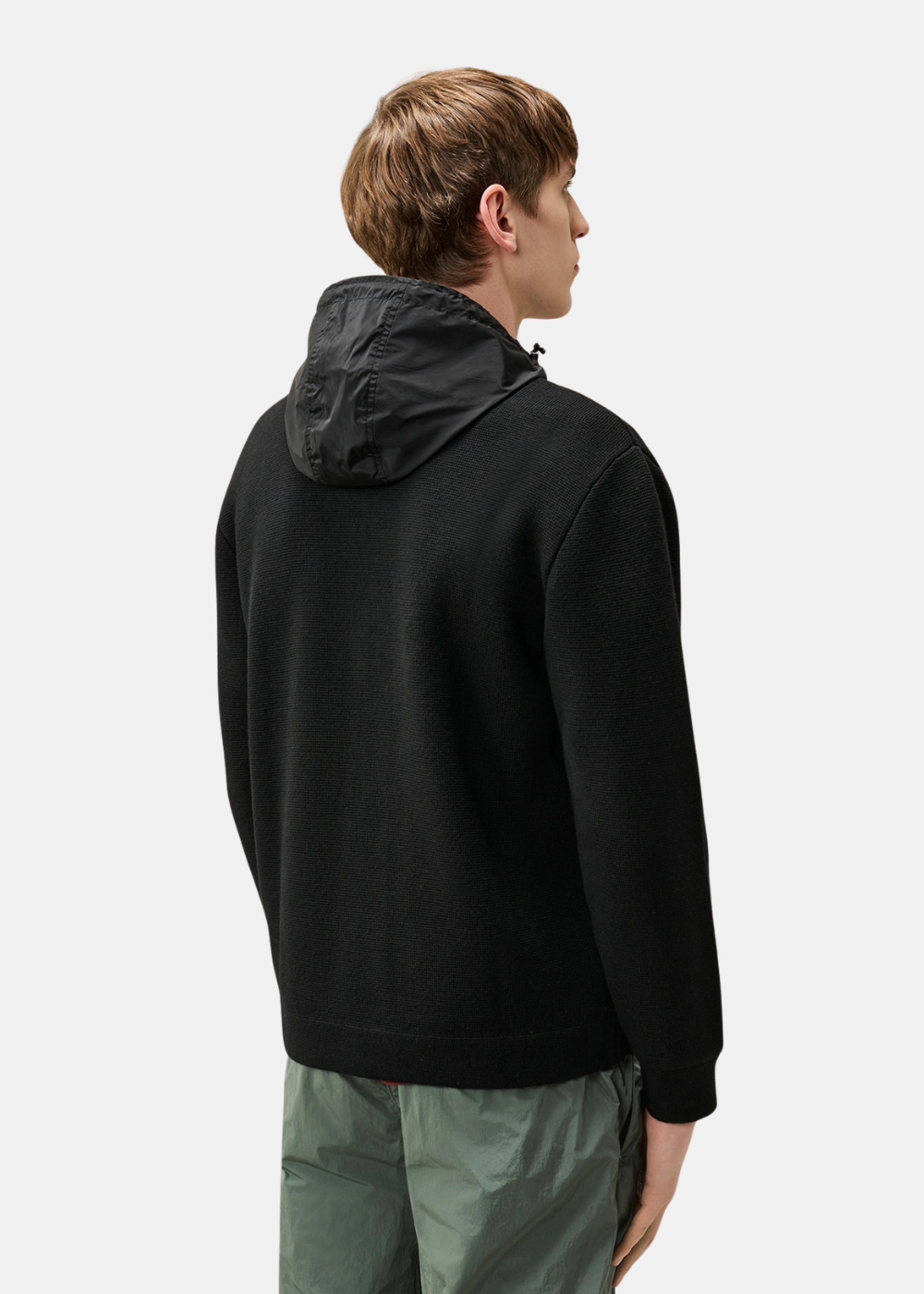 Mannequin homme vu de dos portant le cardigan C.P. Company en maille noire avec la capuche en nylon repliée sur la nuque
