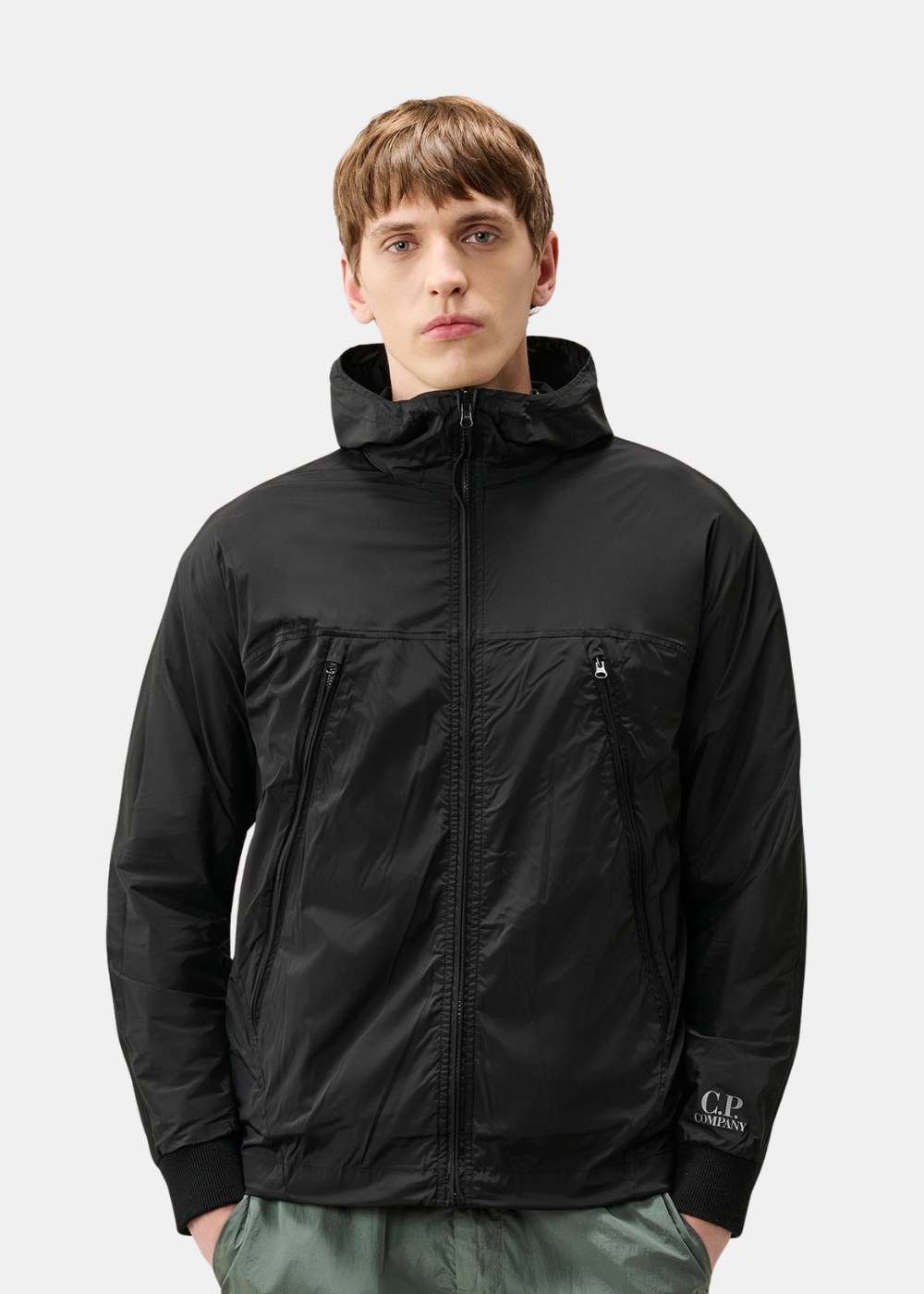Mannequin homme portant le cardigan C.P. Company sur son côté réversible en nylon noir, fermé par un zip central avec des poches poitrines zippées