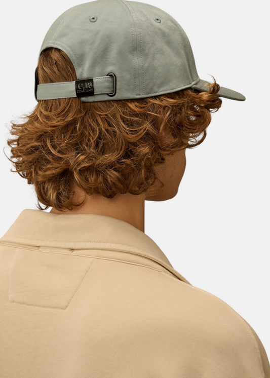 Vue arrière de la casquette bleu C.P. Company portée avec focus sur la sangle de réglage noire