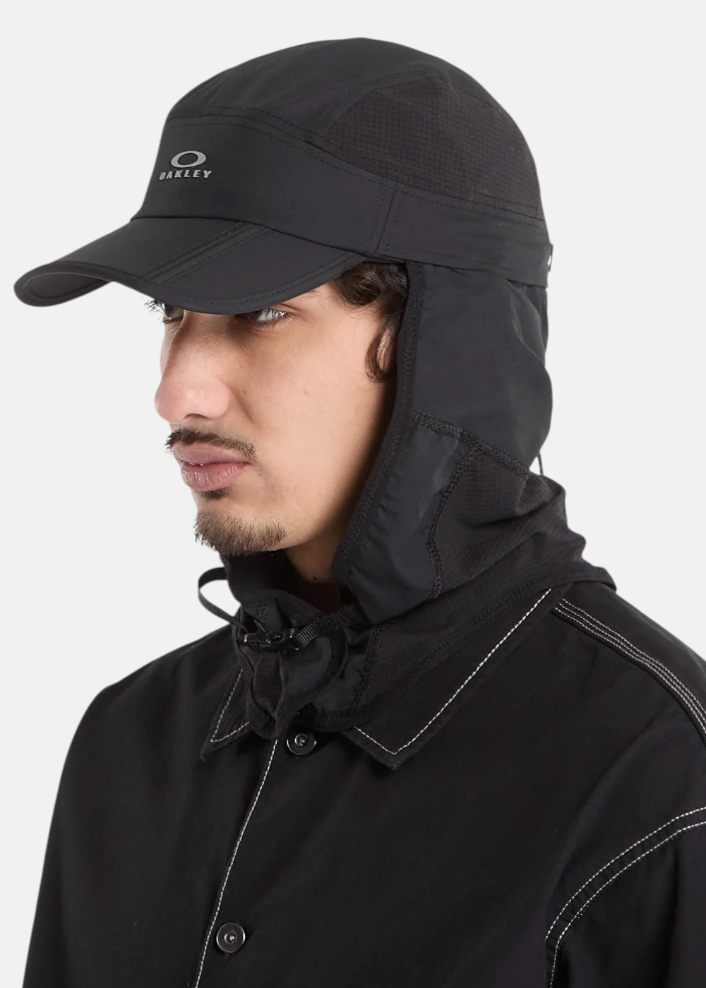 Vue de profil de la casquette Oakley noire montrant la structure technique et les œillets d'aération