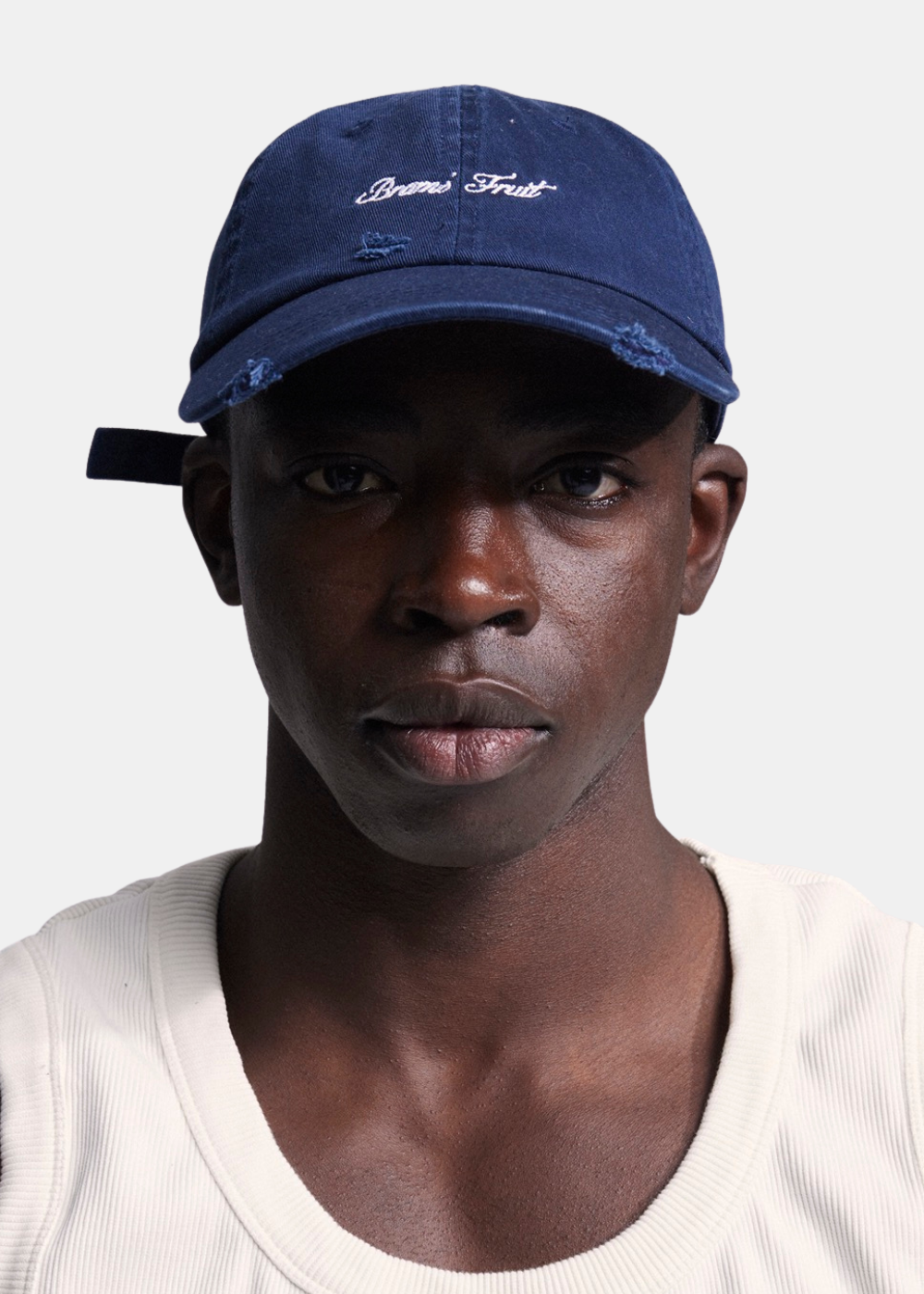Portrait de face d'un homme portant la casquette bleu marine Bram's Fruit avec logo blanc brodé.