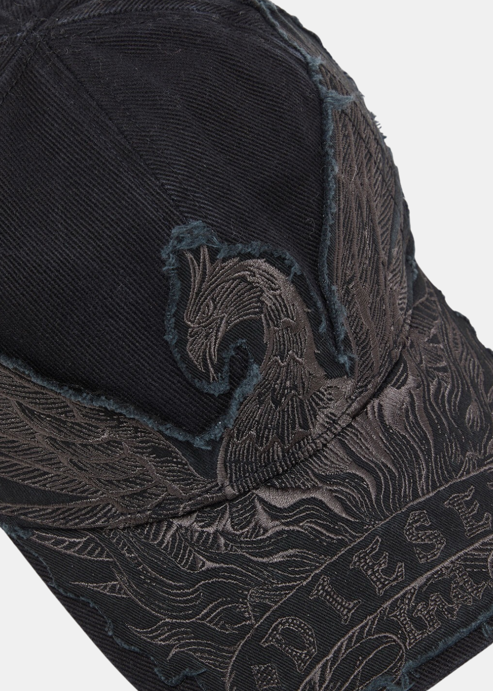 Gros plan sur l'avant de la casquette noire Diesel mettant en valeur les détails de la broderie phoenix blanche et rouge.