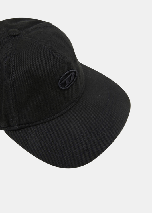 Gros plan en plongée sur l'avant de la casquette noire Diesel, mettant en valeur le logo Oval D brodé ton sur ton