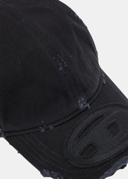 Gros plan sur la visière de la casquette noire Diesel mettant en valeur le logo Oval D brodé et la texture effet usé.