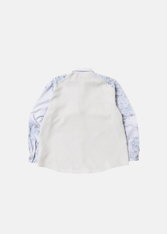 Dos de la chemise technique And Wander, montrant le panneau arrière blanc uni et les manches imprimées.