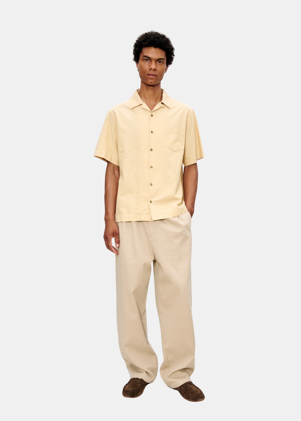 Homme portant une chemise A.P.C. Jude beige à manches courtes avec un pantalon assorti et des chaussures brunes.