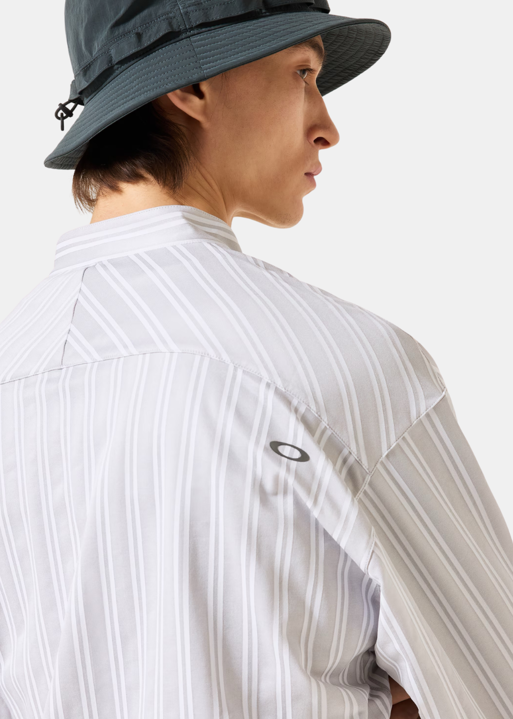 Gros plan de profil sur la chemise Oakley blanche mettant en valeur la matière stretch et la coupe de la manche.