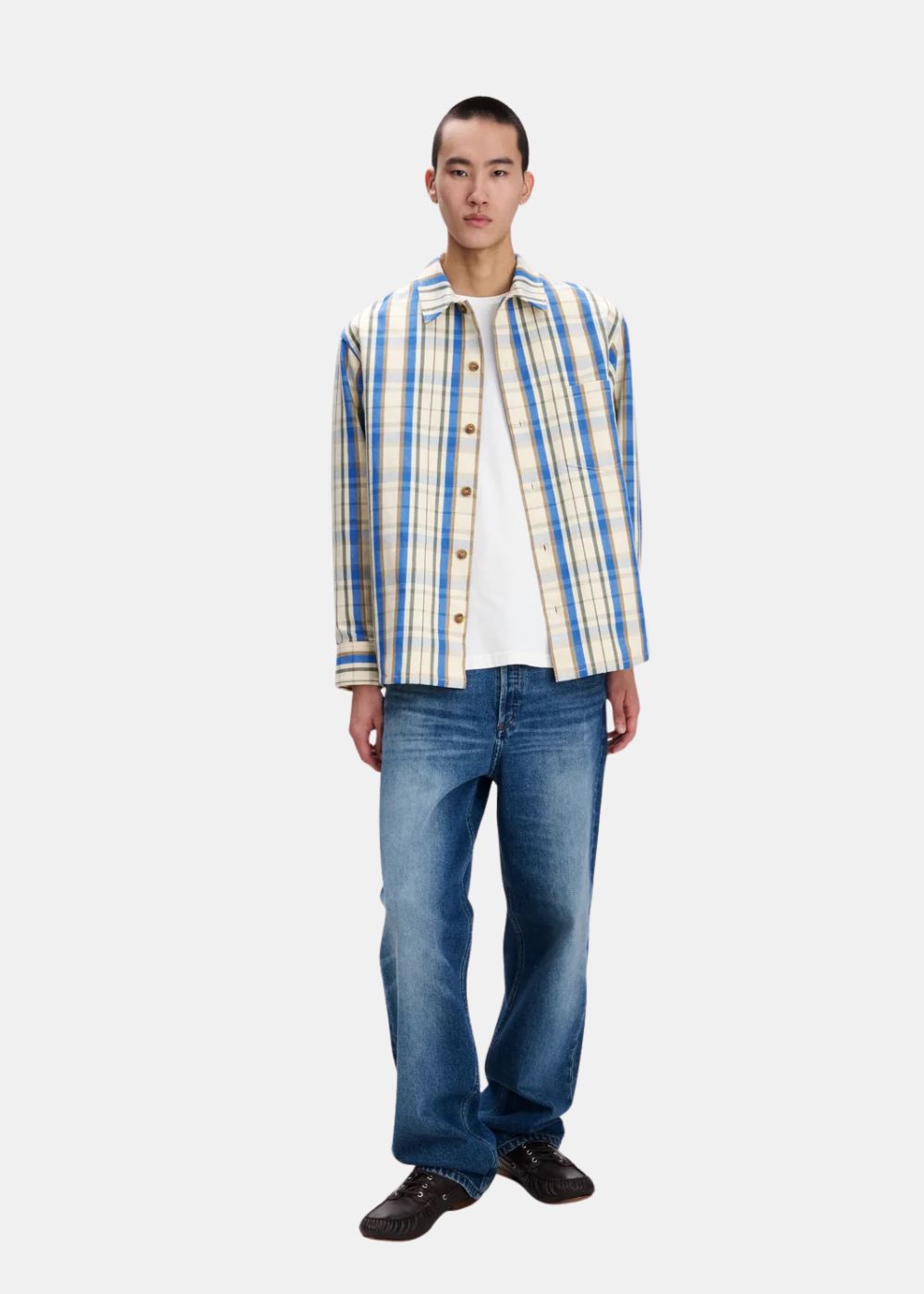 Tenue complète avec la chemise Nathan A.P.C. portée ouverte sur un t-shirt blanc et un jean brut bleu.