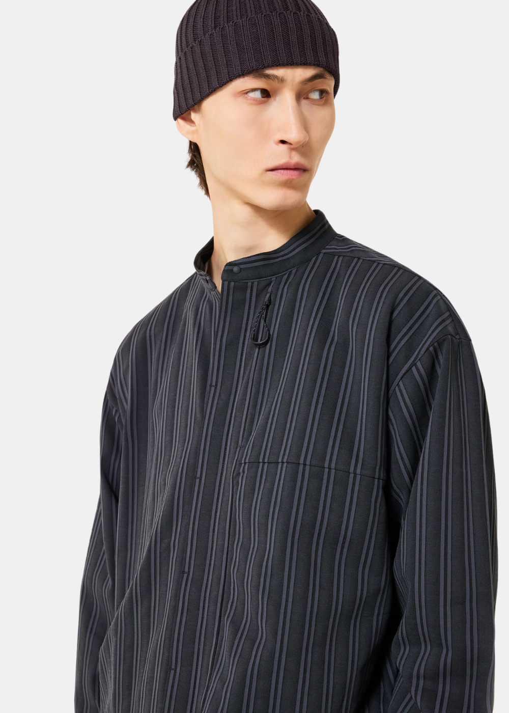 Zoom sur le buste du mannequin portant la chemise Oakley grise, soulignant le col officier et la poche poitrine.