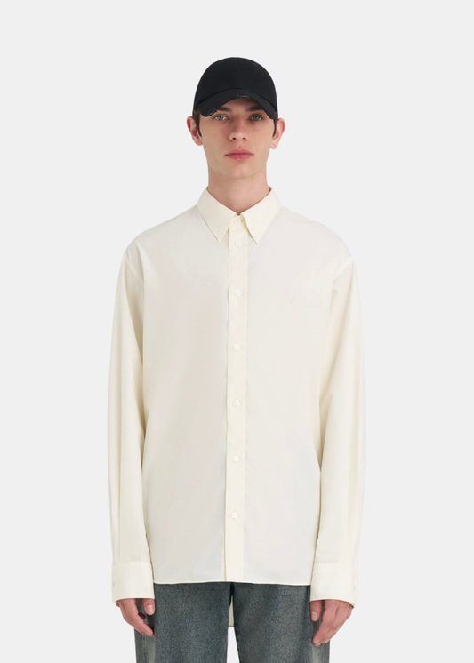 Homme portant une chemise blanc cassé Études Studio Relax É avec une casquette noire et un jean gris