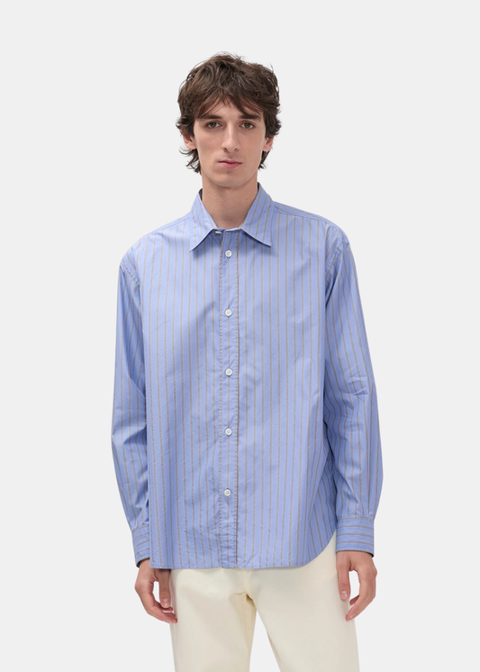 Mannequin de face portant la chemise Norse Projects Espevik bleue rayée avec un pantalon clair