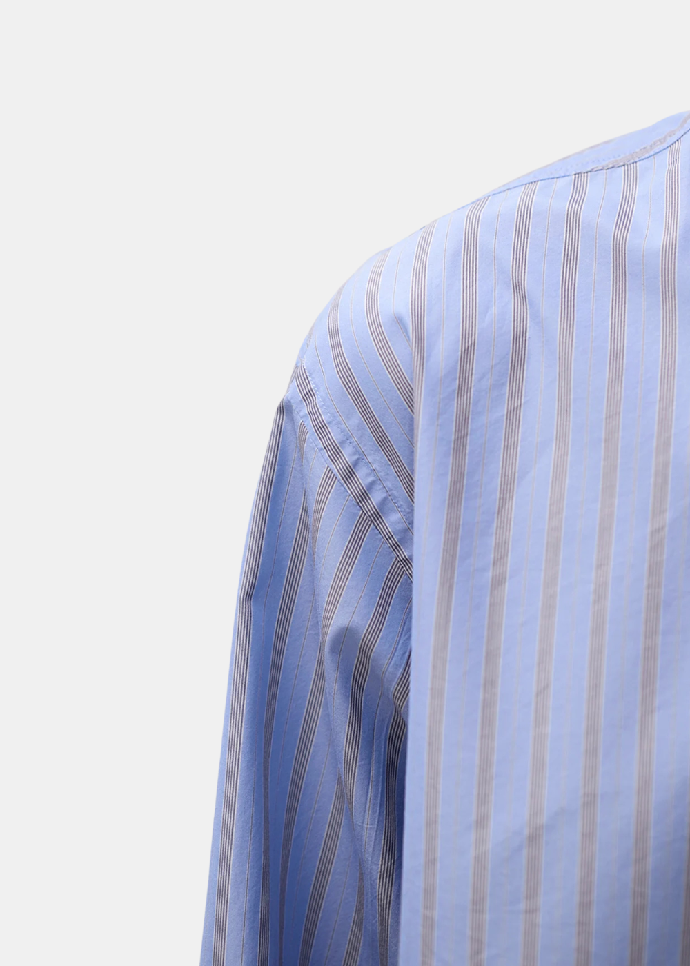 Gros plan sur l'épaule et la texture de la popeline italienne rayée de la chemise Norse Projects