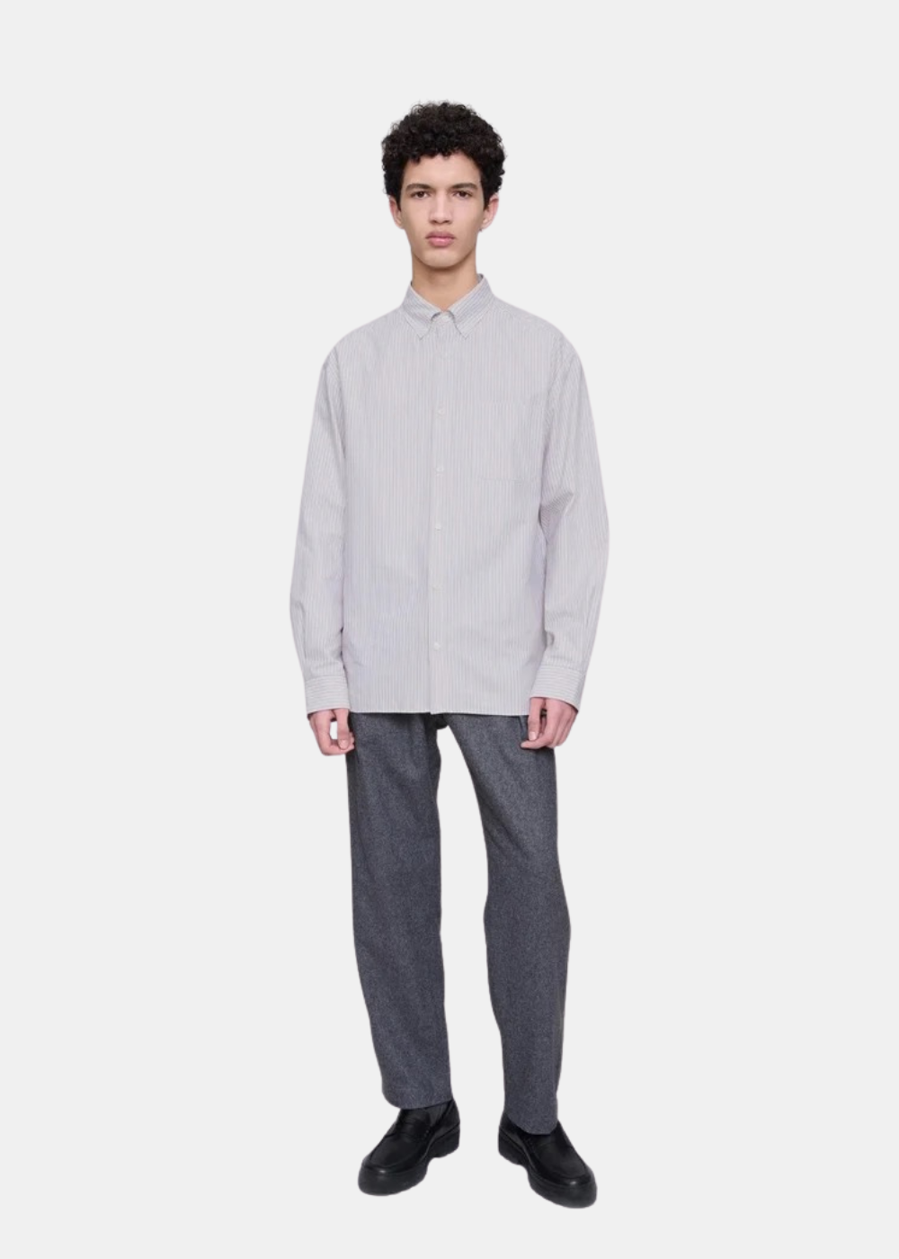 Mannequin homme en pied portant la chemise A.P.C. à rayures avec un pantalon gris et des mocassins