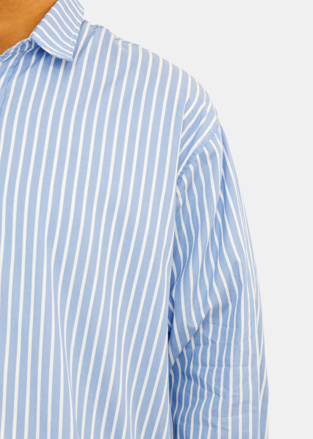 Gros plan sur la couture de l'épaule et le motif à rayures bleu et blanc de la chemise Last Call For Seseh