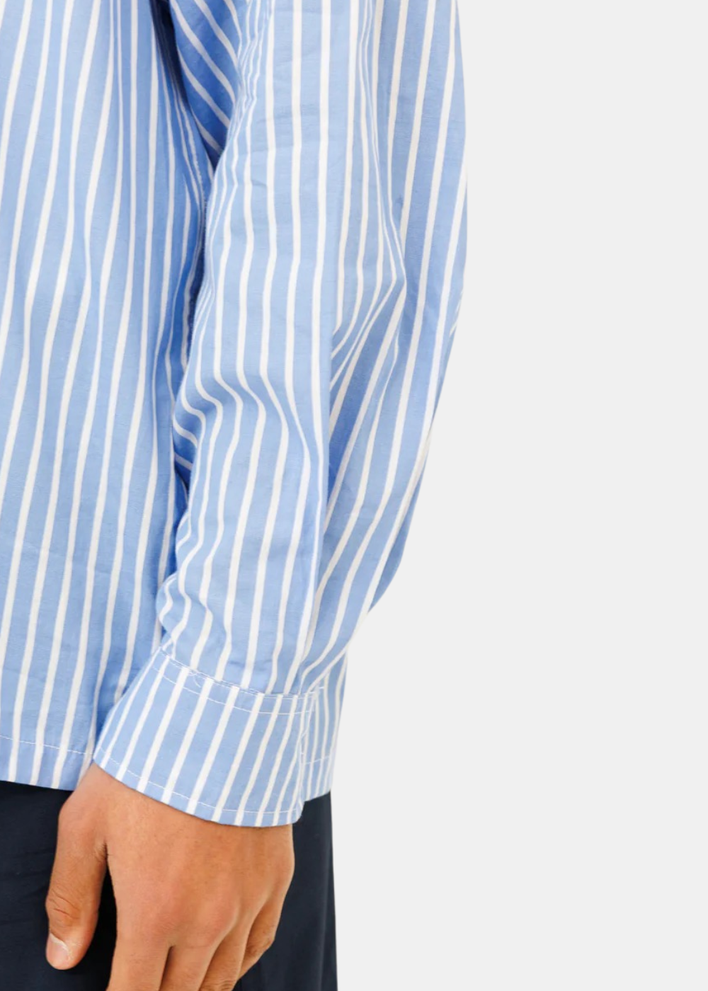 Zoom sur la manche et le poignet boutonné de la chemise à rayures verticales bleu et blanc Last Call For Seseh