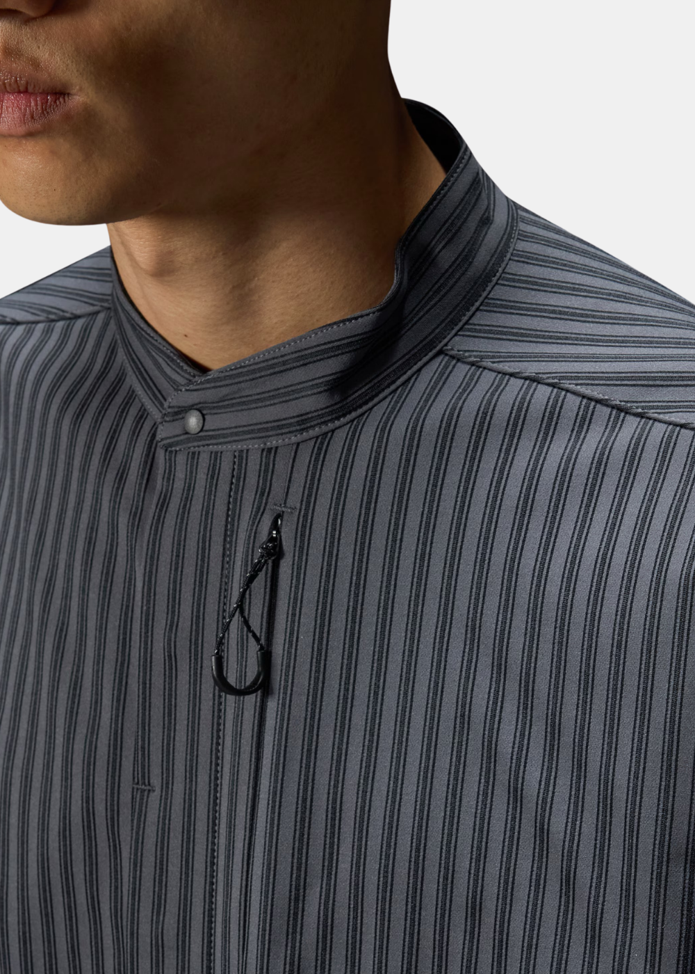 Gros plan sur le col officier boutonnable et le cordon de fermeture éclair de la chemise Oakley FGL Fuel grise rayée