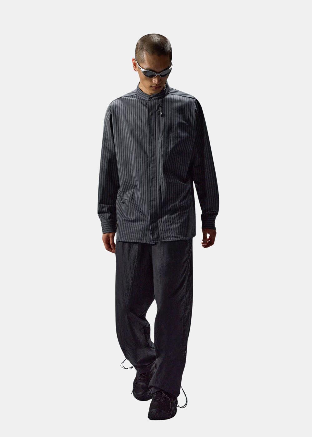 Mannequin avec lunettes de soleil portant la chemise à manches longues Oakley FGL Fuel grise à rayures avec un pantalon noir