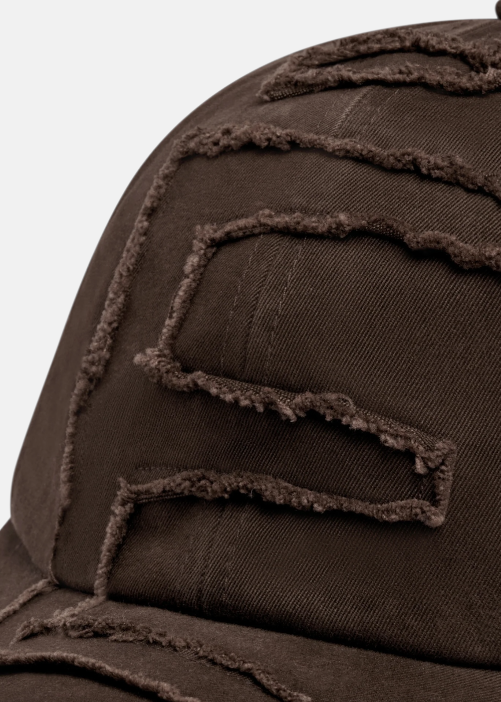 vue et mise en avant du détail déstructé de la Casquette Etudes studio raw 