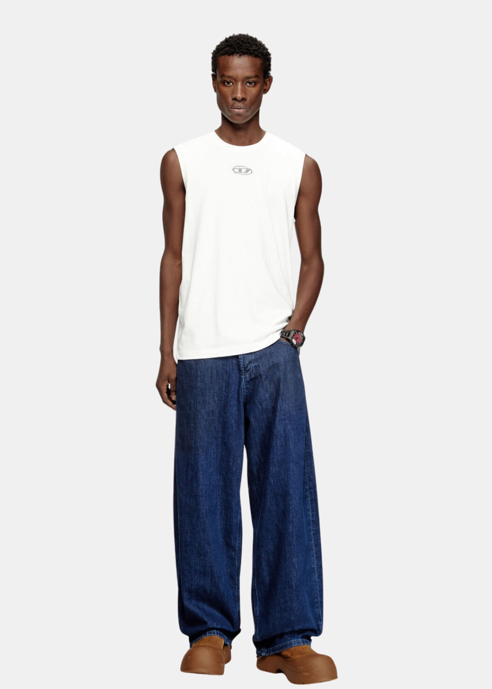 Silhouette complète associant le débardeur blanc Diesel à un jean large bleu en denim et des chaussures en nubuck marron